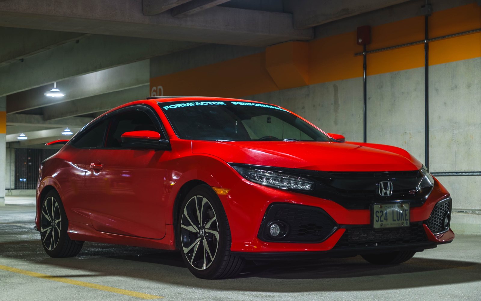Luke's red 2018 Honda Civic Si coupe with a FormFactor Performance windshield banner, in a parking garage
